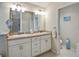 Bright bathroom with double vanity, large mirror, and white cabinets at 2411 Adelphi Ave, The Villages, FL 32162