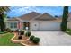 Attractive home with a two-car garage, decorative landscaping, and a welcoming front porch at 2411 Adelphi Ave, The Villages, FL 32162