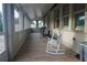 Long enclosed porch with rocking chair and tiled floor at 1199 Playa Del Sol Ln, Saint Cloud, FL 34771