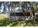 Gray house with a screened porch and large tree at 19402 E 5Th St, Umatilla, FL 32784