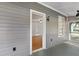 Inviting front porch with grey siding and a view into the home's interior at 19402 E 5Th St, Umatilla, FL 32784