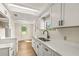 Bright kitchen features white cabinets, quartz countertops, and a modern farmhouse sink at 19402 E 5Th St, Umatilla, FL 32784