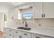 Modern kitchen with white cabinets, quartz countertops, and a black faucet at 19402 E 5Th St, Umatilla, FL 32784