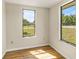 Well-lit bedroom with hardwood floors and two large windows at 19402 E 5Th St, Umatilla, FL 32784