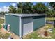 Green metal workshop with a roll-up door at 19402 E 5Th St, Umatilla, FL 32784