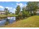 Peaceful backyard oasis featuring a serene pond with lush greenery at 10367 Se Sunset Harbor Rd, Summerfield, FL 34491