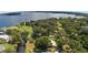 Aerial view showcasing a home on a waterfront lot with lush landscaping at 10367 Se Sunset Harbor Rd, Summerfield, FL 34491