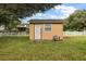 Small yellow shed in backyard with white picket fence at 10367 Se Sunset Harbor Rd, Summerfield, FL 34491