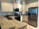 Modern kitchen with stainless steel appliances and granite countertops at 124 Orange Ave, Clermont, FL 34711