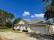 Front view of a single-story house with a driveway and landscaping at 390 Colonade Ct, Kissimmee, FL 34758