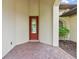 Front entry with a red door and brick flooring at 39644 Harbor Hills Blvd, Lady Lake, FL 32159