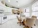 Eat-in kitchen with white cabinets, appliances, and tile floor at 4706 Glen Coe St, Leesburg, FL 34748