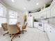 Eat-in kitchen with white cabinets, appliances, and tile floor at 4706 Glen Coe St, Leesburg, FL 34748