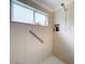 Walk-in shower with tiled walls, grab bar, and built-in shelves at 4706 Glen Coe St, Leesburg, FL 34748