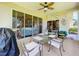 Screened porch with glass doors, seating, and backyard access at 4706 Glen Coe St, Leesburg, FL 34748