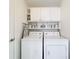 Bright laundry room with washer, dryer, and ample storage shelving at 4706 Glen Coe St, Leesburg, FL 34748