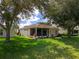 Landscaped backyard with screened patio and large trees at 4706 Glen Coe St, Leesburg, FL 34748