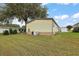 Rear view of manufactured home, showcasing landscaping and AC unit at 1605 W Schwartz Blvd, The Villages, FL 32159