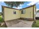 Yellow single-wide manufactured home with carport and small yard at 1605 W Schwartz Blvd, The Villages, FL 32159