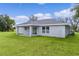Gray house with a covered patio and grassy backyard at 5 Malauka Radial Run Rd, Ocklawaha, FL 32179