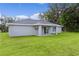 Gray house with a covered patio and grassy backyard at 5 Malauka Radial Run Rd, Ocklawaha, FL 32179