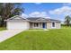 Single story home with attached garage and grassy lawn at 5 Malauka Radial Run Rd, Ocklawaha, FL 32179