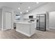 Modern kitchen with white cabinets, island, and stainless steel appliances at 5 Malauka Radial Run Rd, Ocklawaha, FL 32179