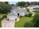 Single-story house with a two-car garage and a spacious lawn at 33936 Highland Rd, Leesburg, FL 34788