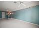 Large bedroom with teal walls, plush carpeting, and ceiling fans at 5008 Greenbriar Trl, Mount Dora, FL 32757