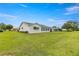 Side view of a single story home with green awnings and a large lawn at 9823 Se 178Th Ln, Summerfield, FL 34491