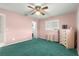 Bedroom with green carpet, ceiling fan, and built-in dresser at 9823 Se 178Th Ln, Summerfield, FL 34491