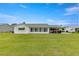 Back of the house showing a large covered patio and grassy yard at 9823 Se 178Th Ln, Summerfield, FL 34491