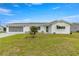 White single story home with green awnings and a well-manicured lawn at 9823 Se 178Th Ln, Summerfield, FL 34491