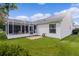 White house with screened porch and grassy backyard at 17913 Se 88Th Cascade Ct, The Villages, FL 32162
