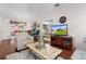 Bright living room with hardwood floors, comfy seating, and a large TV at 17913 Se 88Th Cascade Ct, The Villages, FL 32162