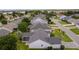 An aerial view showcasing a house's rear elevation, featuring a grey roof and screened enclosure at 17913 Se 88Th Cascade Ct, The Villages, FL 32162