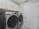 Convenient laundry room with washer, dryer, and cabinets at 3162 Webster Way, The Villages, FL 32163