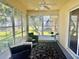 Relaxing screened porch with wicker furniture and view of backyard at 1213 El Esparza Ln, The Villages, FL 32159