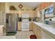 Bright kitchen featuring white appliances and light wood cabinets at 1213 El Esparza Ln, The Villages, FL 32159