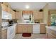 Bright kitchen with white appliances and light wood cabinets at 1213 El Esparza Ln, The Villages, FL 32159