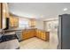 L-shaped kitchen with wood cabinets and stainless steel appliances at 306 Bishopville Loop # 117, The Villages, FL 32162