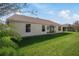 House exterior and spacious backyard with green grass at 306 Bishopville Loop # 117, The Villages, FL 32162