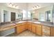 Bathroom with double vanity, light wood cabinets, and a large mirror at 306 Bishopville Loop # 117, The Villages, FL 32162