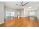Open living room with hardwood floors, a ceiling fan, and views of the backyard at 306 Bishopville Loop # 117, The Villages, FL 32162