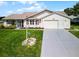 House and yard aerial view showcasing a two-car garage and landscaping at 6401 Tildon, Leesburg, FL 34748