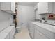 Bright laundry room, washer, dryer, toilet, and storage cabinets at 6401 Tildon, Leesburg, FL 34748