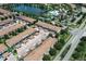 Aerial view of community with townhouses, lake, pool, and sports facilities at 2019 Majorca Dr, Kissimmee, FL 34747