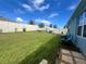 Spacious backyard with grassy lawn, swing set, patio furniture, and privacy fence at 1771 Henin Cir, Tavares, FL 32778