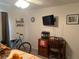 Bedroom with desk, chair, mounted TV, and bicycle at 16360 Sw 15Th Ct, Ocala, FL 34473