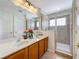 Bathroom with double sinks, wood cabinets, and shower at 426 Orange Cosmos Blvd, Davenport, FL 33837